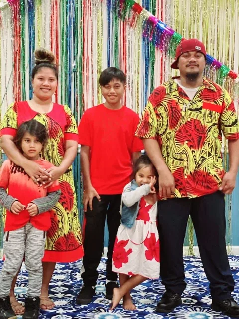 Family of five in front of colorful streamers.