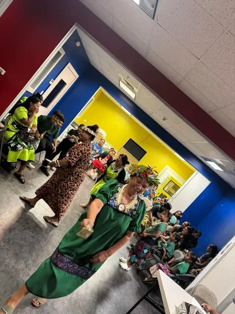 People in colorful clothing gathered in a room.